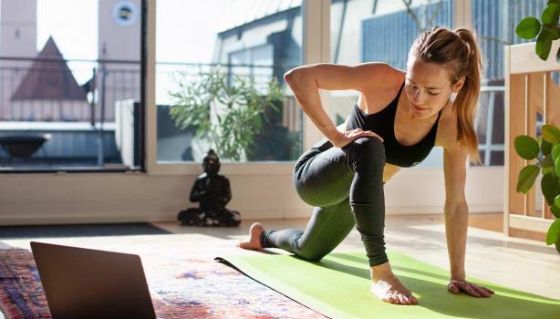 Mujer estirando en casa y haciendo ejercicios de cardio para principiantes