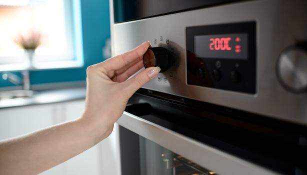 Persona ajustando temperatura en horno, termómetro de cocina