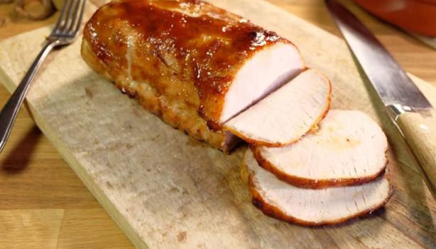 Porchetta rebanada sobre tabla de picar.