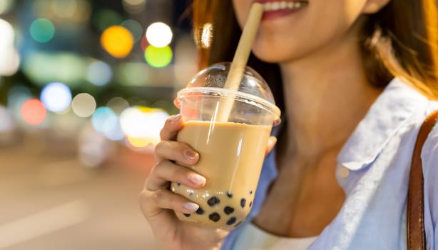 Mujer disfrutando de una bebida complementada con perlas de tapioca.