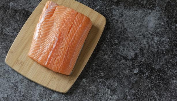 Filete de salmón fresco sobre tabla de madera