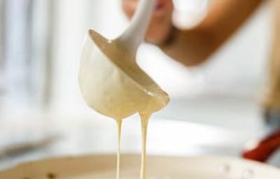 Una mujer preparando panqueques con un cucharón Una mujer preparando panqueques con un cucharón