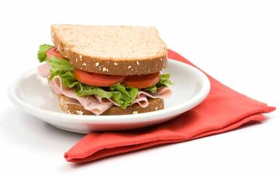 Un sándwich clásico de jamón, lechuga y tomate, uno de los snacks saludables más populares Un sándwich clásico de jamón, lechuga y tomate, uno de los snacks saludables más populares
