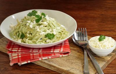 Pasta aromatizada con cilantro, servida en un plato blanco. Pasta aromatizada con cilantro, servida en un plato blanco.