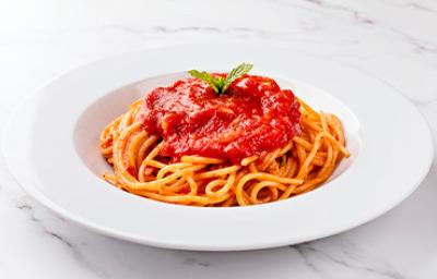 La salsa pomodoro combina muy bien con las pastas. Espagueti con salsa pomodoro, servido en un plato blanco.