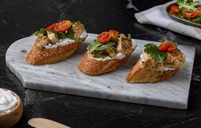 Tapas españolas con tomate, queso crema, albahaca y pollo.