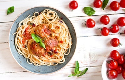 Espagueti con una salsa boloñesa italiana y albóndigas con unas hojitas de albahaca.