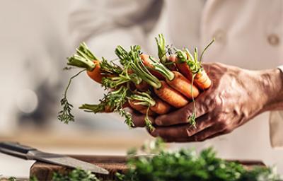 Persona cocinando con zanahorias y creando su plantilla de menú semanal. Persona cocinando con zanahorias y creando su plantilla de menú semanal.
