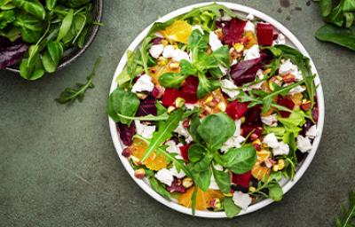 Ensalada en cenital con hojas verdes, remolacha, queso y frutos cítricos, un plato que puedes conservar en casa