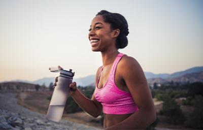 Mujer haciendo deporte e hidratándose con botella reutilizable Mujer haciendo deporte e hidratándose con botella reutilizable
