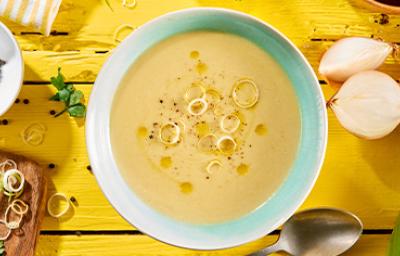 Vichyssoise en un tazón, mesa amarilla con ingredientes frescos Vichyssoise en un tazón, mesa amarilla con ingredientes frescos