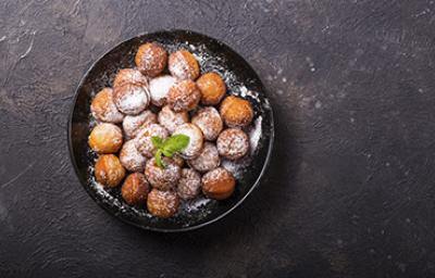 Plato de buñuelos de yuca espolvoreados vistos desde un ángulo cenital.