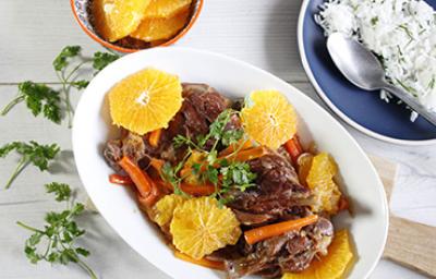 Cerdo con salsa de naranja, rodajas y arroz blanco Plato de cerdo con salsa de naranja, acompañado de rodajas de naranja