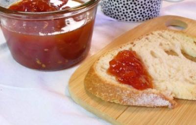 Rebanada de pan con mermelada casera de fresa, recipiente de vidrio sobre tabla