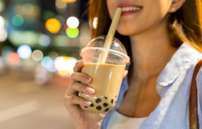 Mujer disfrutando de una bebida complementada con perlas de tapioca.