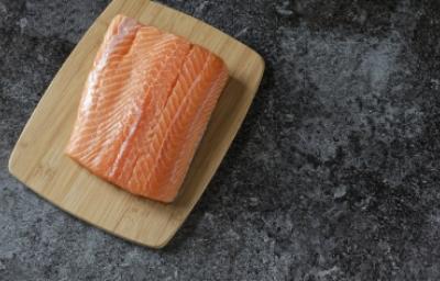 Filete de salmón fresco, uno de los tipos de salmón más usados Filete de salmón fresco sobre tabla de madera