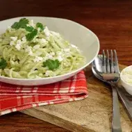 Pasta aromatizada con cilantro, servida en un plato blanco.