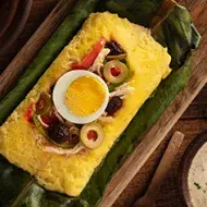 Plato con tamales dulces y salados envuelto en hoja de choclo  