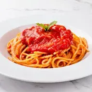 Espagueti con salsa pomodoro, servido en un plato blanco. 