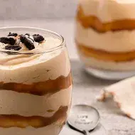 Postre de limón en vaso, decorado con frutas.