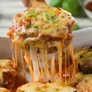 Berenjenas a la parmesana con salsa de tomate, una receta vegetariana popular. 