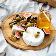 Tabla de quesos con miel, frutas y aceitunas  |