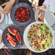 Mesa de picnic con ensalada con pasta y frutas 