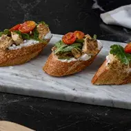 Tapas españolas con tomate, queso crema, albahaca y pollo.