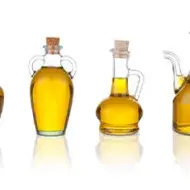 Cuatro jarras con aceite de ajonjolí en un fondo blanco Cuatro jarras con aceite de ajonjolí en un fondo blanco