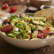 Ensalada mediterránea en una mesa con diferentes acompañamientos