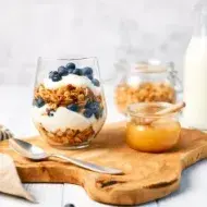 Granola con yogurt griego y miel para alimentarse saludablemente.