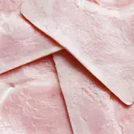 Primer plano de lonchas de jamón cocido, un ejemplo de alimentos ultraprocesados