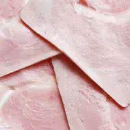 Primer plano de lonchas de jamón cocido, un ejemplo de alimentos ultraprocesados