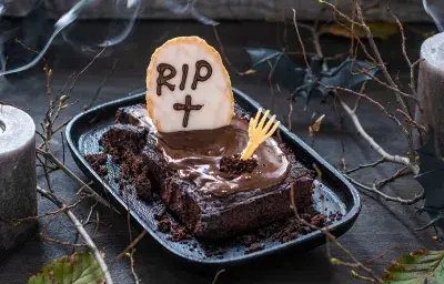 Brownies de Halloween con galletas RIP y velas como decoración