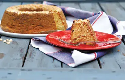 Un plato blanco contiene el pastel y uno rojo una rebanada con un tenedor. Abajo, un paño en azul y blanco.