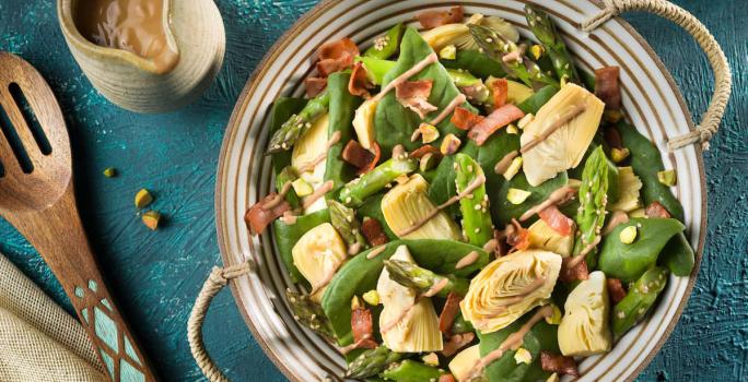 Incorpora el aderezo a la ensalada y mezcla bien cubriendo todos los vegetales. decora con los pistachos picados y sirve enseguida.