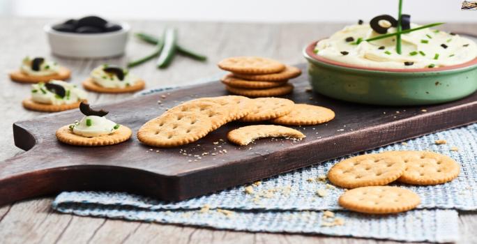 Receta dip de queso crema, aceitunas y cebollin con galletas Ricas®.