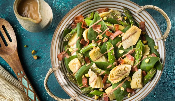 Incorpora el aderezo a la ensalada y mezcla bien cubriendo todos los vegetales. decora con los pistachos picados y sirve enseguida.